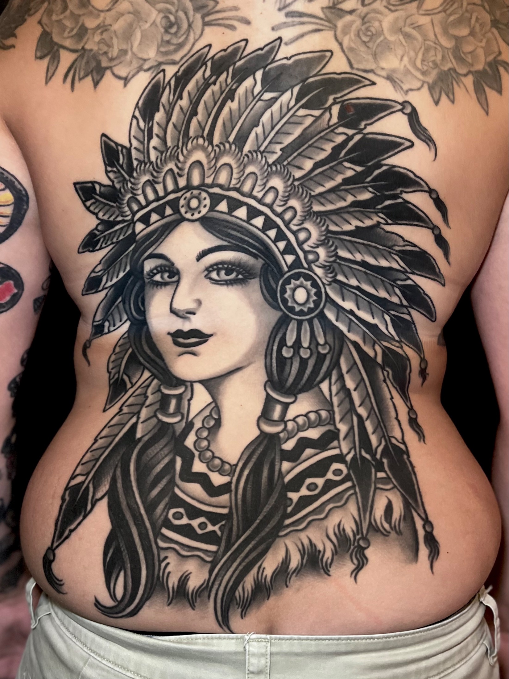American traditional Native American girl wearing a headdress full back tattoo